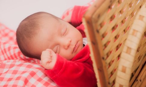 竹の衝立の側でお昼寝をしている赤いおべべの赤ちゃん