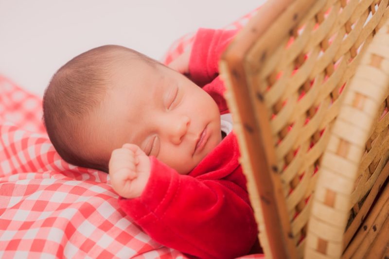竹の衝立の側でお昼寝をしている赤いおべべの赤ちゃん