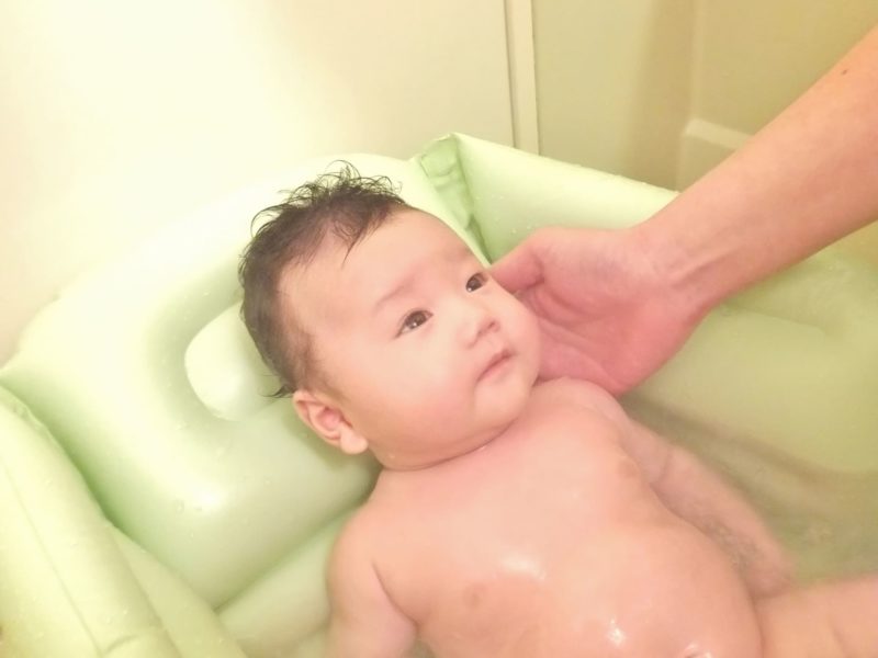 親御さんの手によって沐浴を行われている赤ちゃん