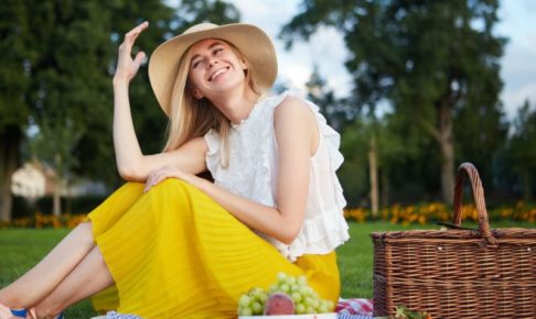 黄色いスカートで帽子を被った外国人女性ピクニック