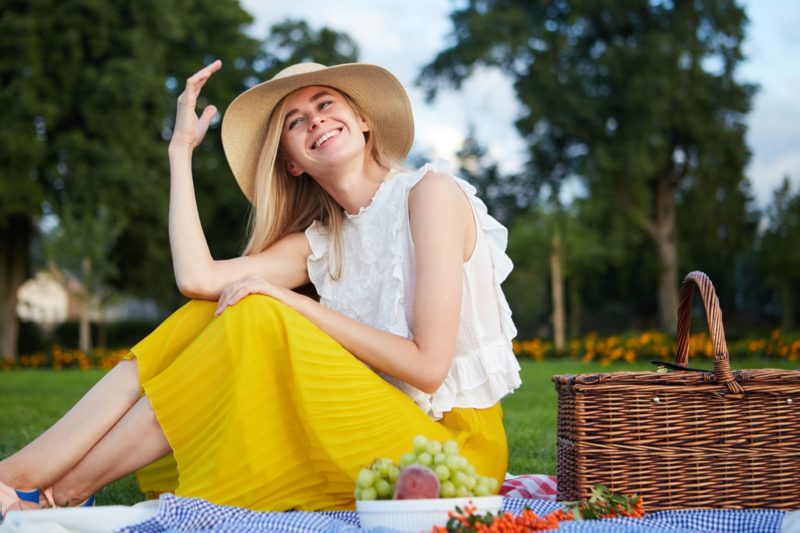 黄色いスカートで帽子を被った外国人女性ピクニック