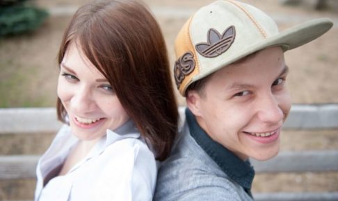 背中合わせに座って笑っている男女のアップ