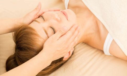 顔のマッサージの施術を受けている女性