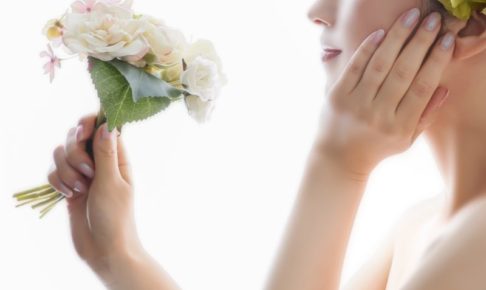 花をもって頬に手を当てる女性