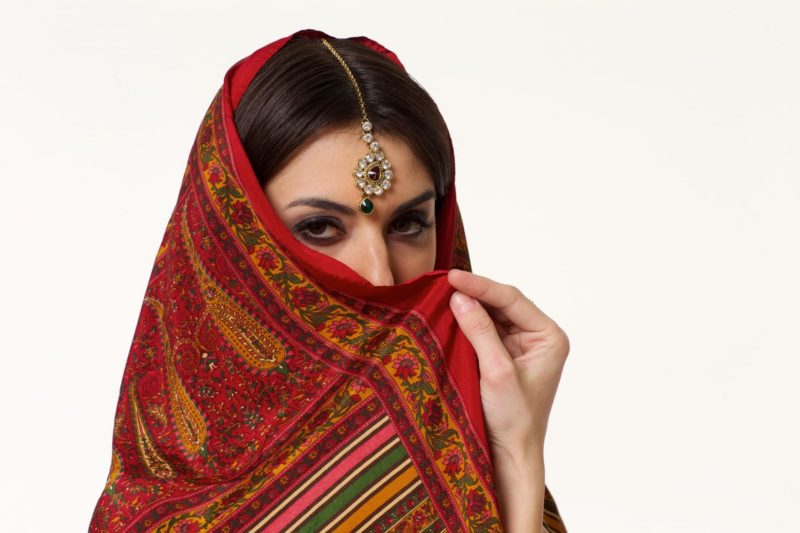 赤いスカーフで顔を隠した中東風な女性