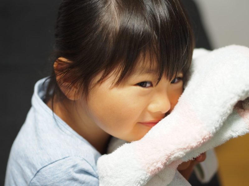白いタオルで顔を拭く女の子