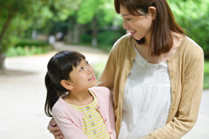 肩を寄せ見つめ合う母と女の子