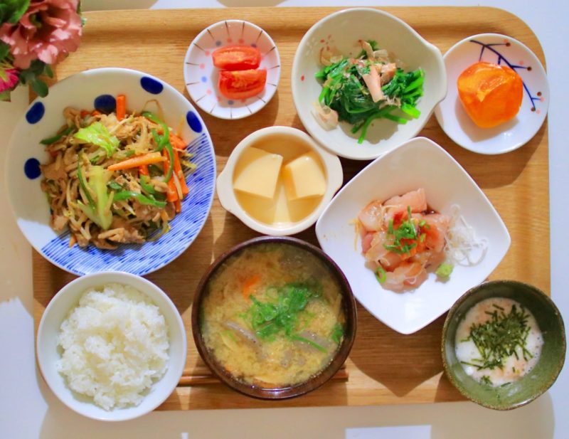 木のお膳に乗った9品の料理