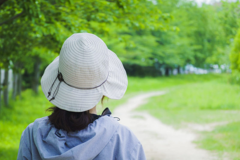 白い帽子と水色の服で紫外線対策をした女性