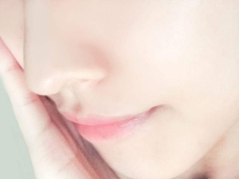 頬に手を当てた女性の口元アップ