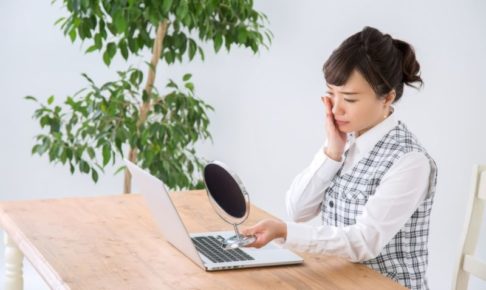 鏡を見て悩むビジネスウーマン