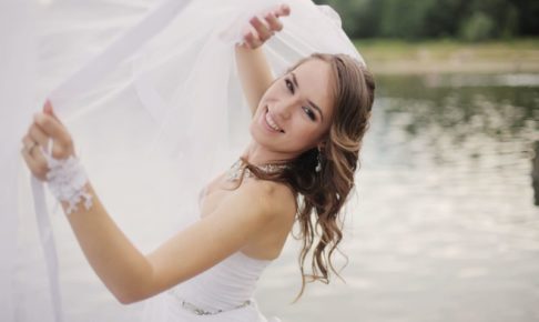 池をバックにウエディングドレス姿の女性