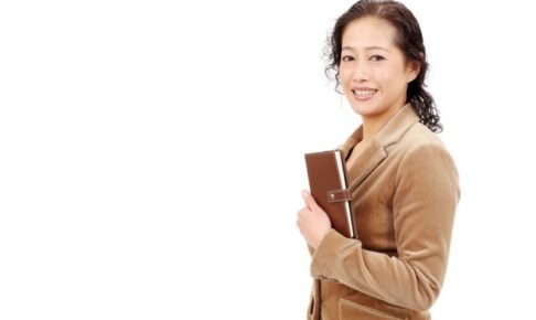 茶色いスーツを着てプレゼンを始めようとしているミセス