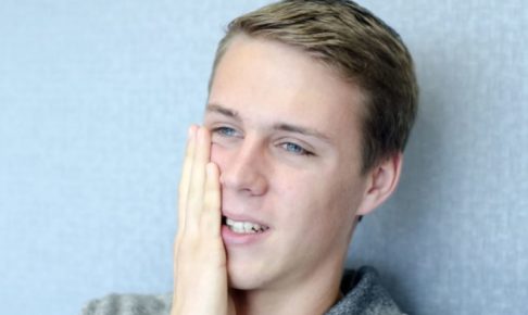 ショックを受けて右頬を押さえる金髪碧眼の男性