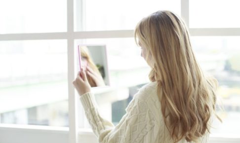 自分の顔のたるみが気になる外国人女性の後ろ姿