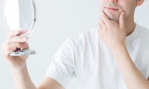 手鏡を気にする成人男性