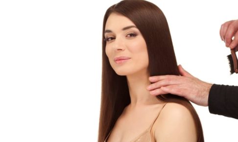 ヘアメイクをしてもらっている茶髪の白人女性