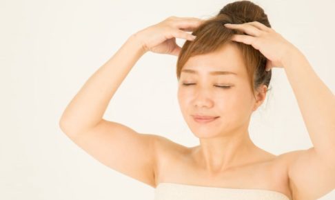 両手で頭皮をマッサージする女性