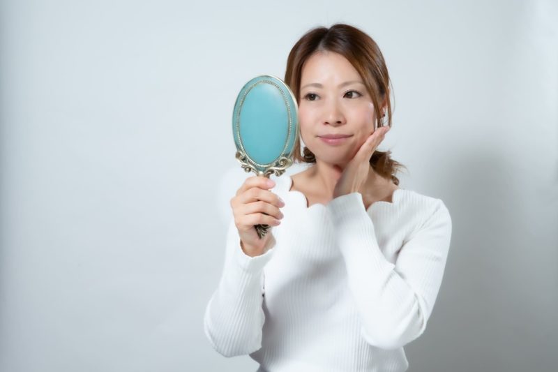 顔の状態を気にする女性