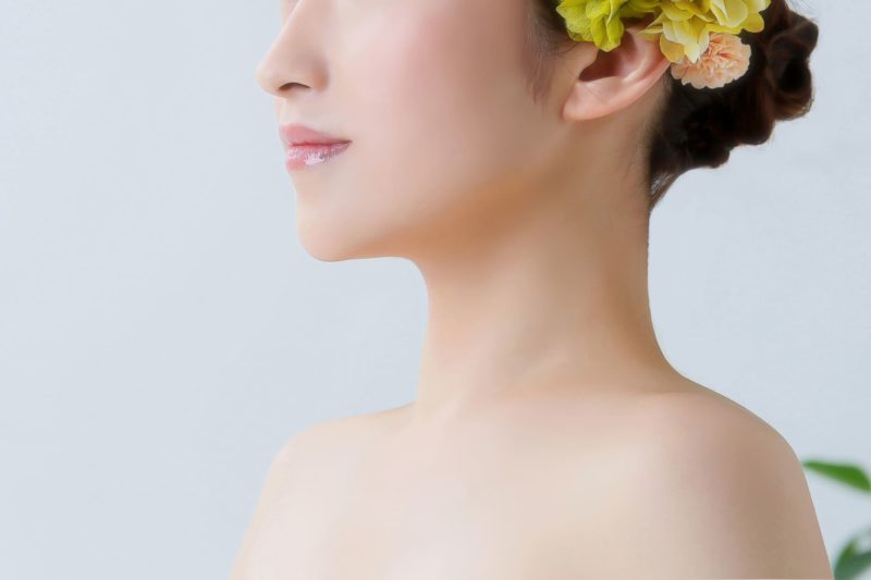 デコルテから上の肌かの女性が左方向に体ごと向けている