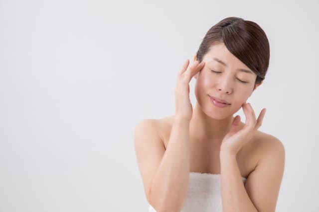 顔をマッサージする女性