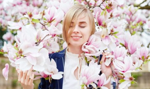 淡い木蓮の花に囲まれてうっとりしている外国人女性