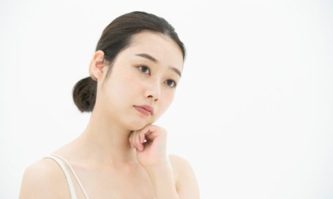 首をかしげて悩む女性