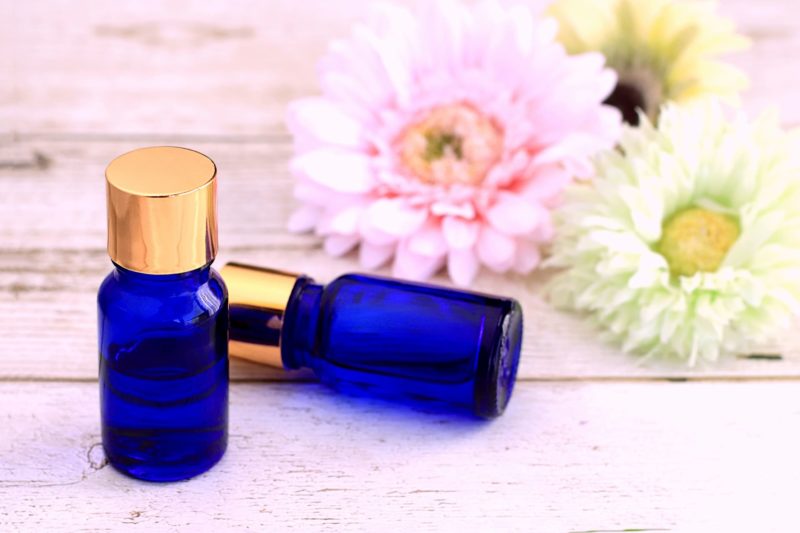 白と薄ピンクの花を置いてその前にある青い瓶２つ