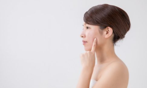 頬を指で触れる女性