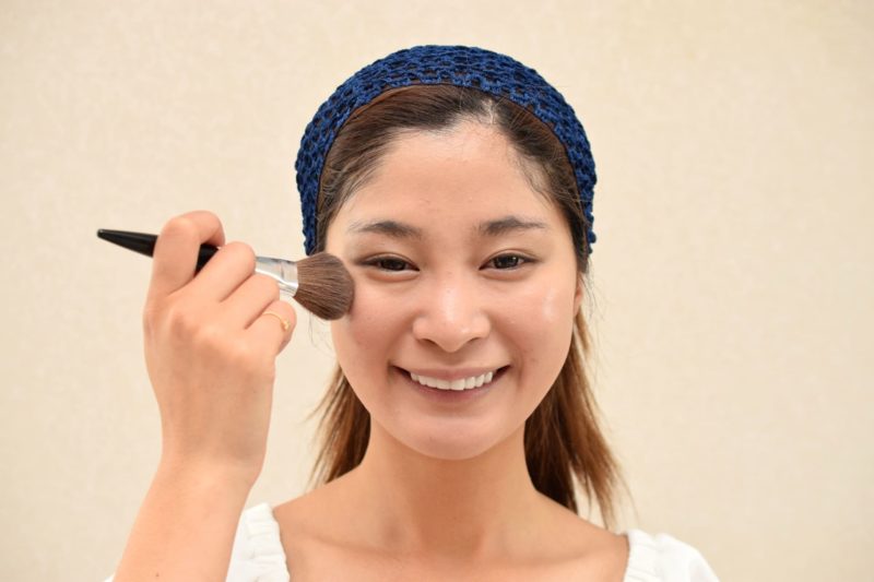 フェイスパウダーをつける女性