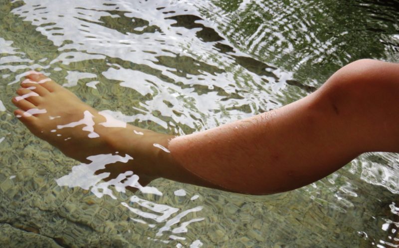 足湯に浸かってむくみを癒す女性