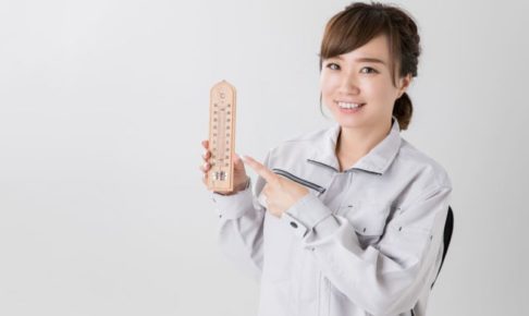 作業着を着て温度を計っている女性