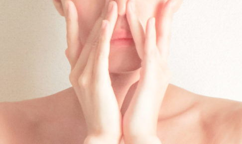 鼻を両手で押さえる女性