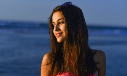 夏の夕暮れの海で陽を浴びている外国人女性のアップ