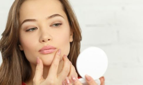 コンパクトで自分の口元を気にする外国人女性