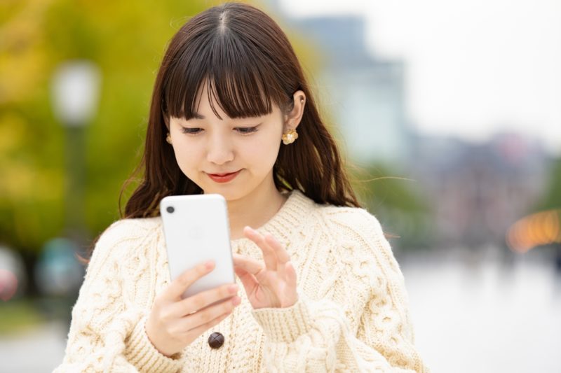 スマホを操作している女性の画像