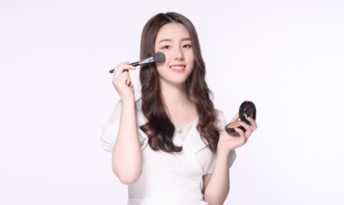 ベージュのチークを塗っているロングヘアの美女