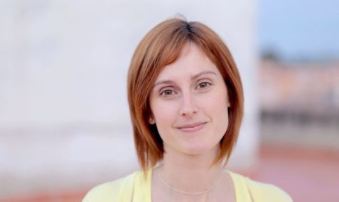 黄色いカーデを着たボブヘアの外国人女性