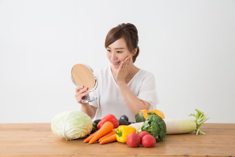 鏡でくすみを気にする女性