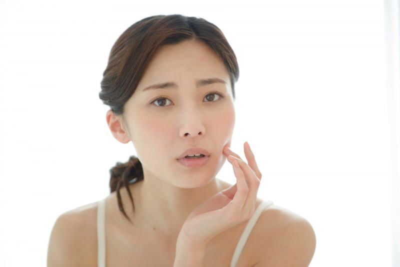 左手で肌を気にする女性