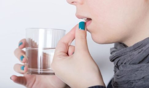 サプリメントを水で飲む女性