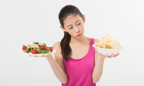 野菜とポテチを手に持っている女性