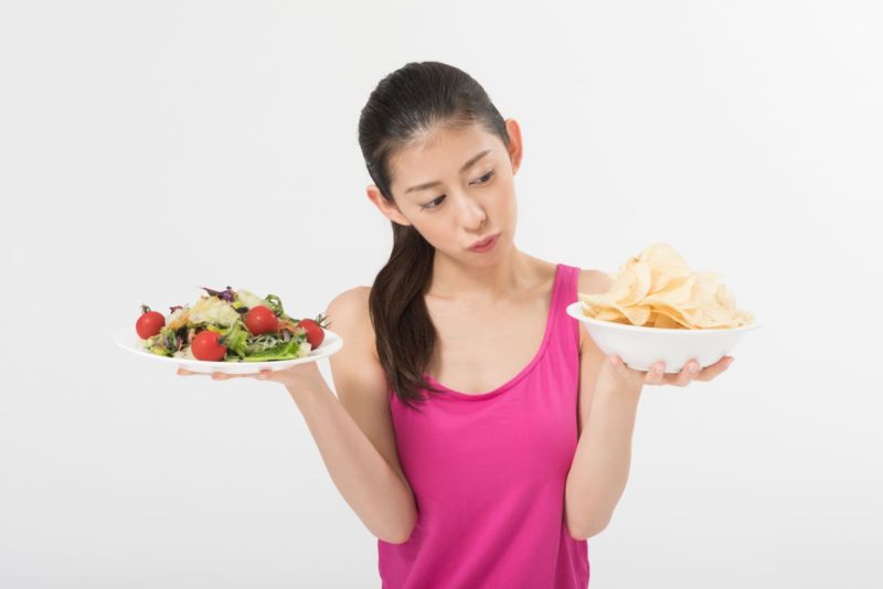 野菜とポテチを手に持っている女性