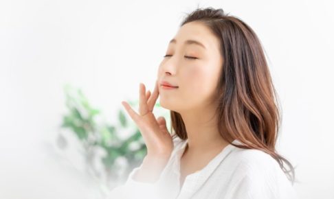 化粧品をつけてうっとりしている女性