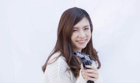 笑顔で銃を構える女性