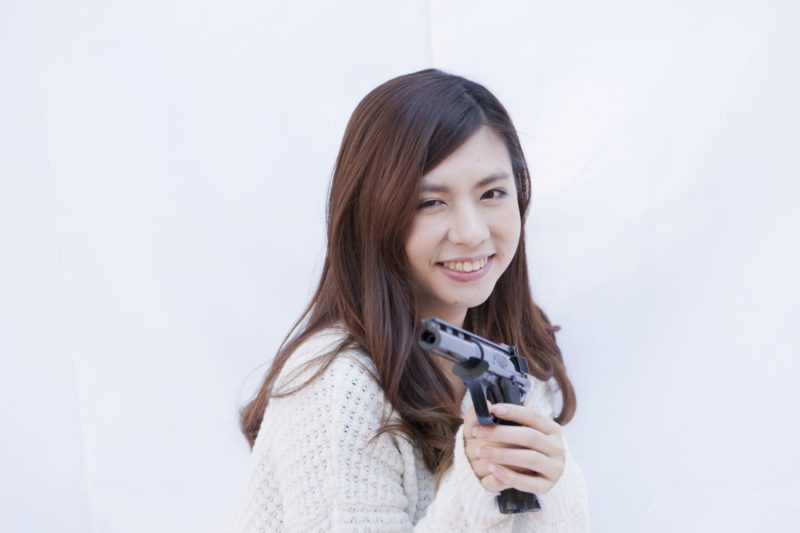 笑顔で銃を構える女性