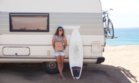 ワゴンの日陰のところに避難している女性サーファー