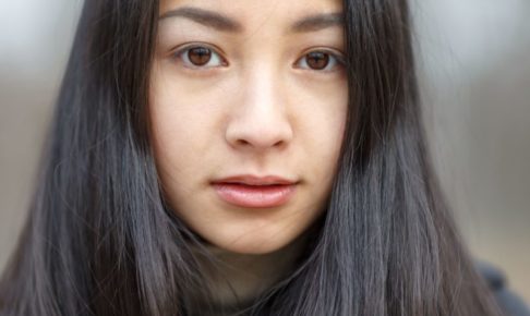 黒い長い髪の女性のキッとした表情のアップ
