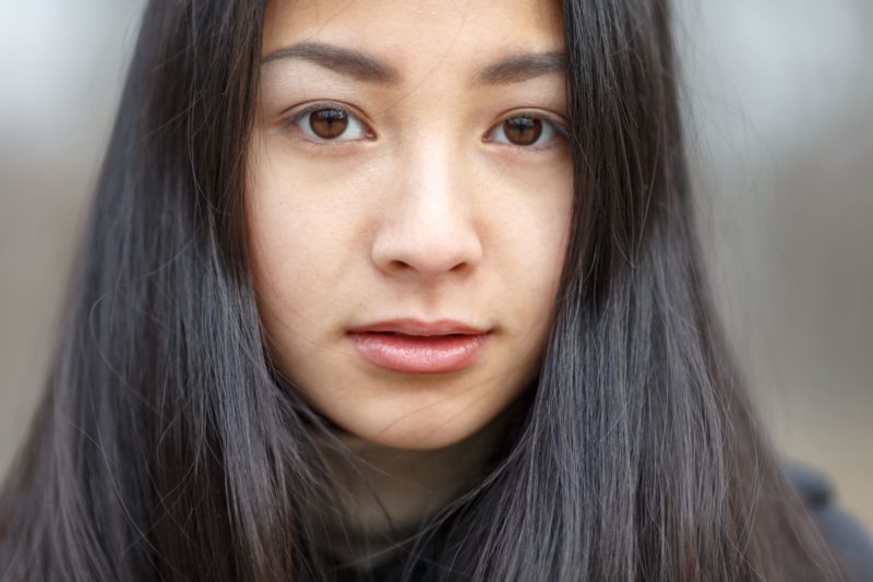 黒い長い髪の女性のキッとした表情のアップ