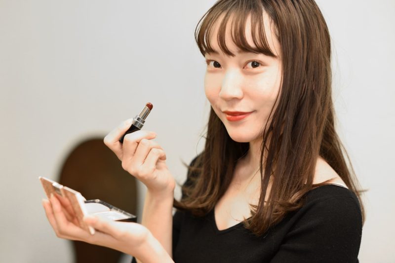 口紅の出来を満足そうに微笑む女性